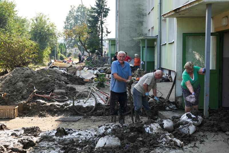 © Reuters. Local residents clean up after floods in Glucholazy, Poland, September 18, 2024. REUTERS/Janis Laizans