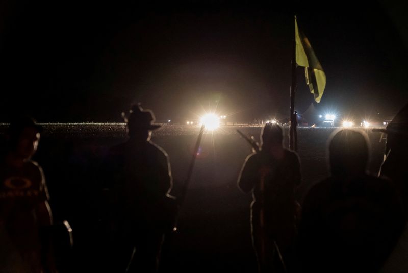 © Reuters. FILE PHOTO: Guarani-Kaiowa Indigenous people, who are reclaiming land, stand guard during a conflict with men backed by farmers in trucks and tractors in Douradina district, state of Mato Grosso do Sul, Brazil August 3, 2024. REUTERS/Gabriel Schlickmann/File Photo