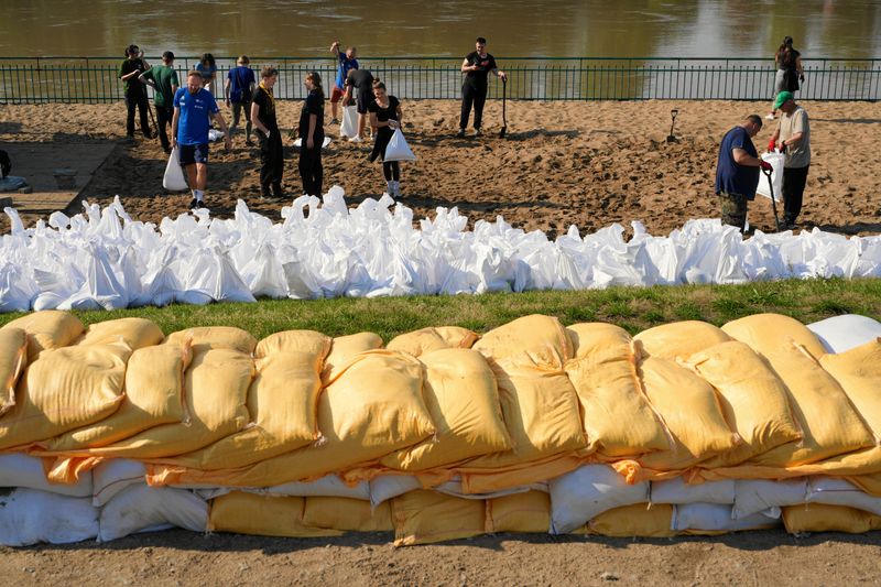 © Reuters. FILE PHOTO: People stand near sandbags protecting the Wroclaw Zoo against flooding, in Wroclaw, Poland, September 18, 2024. Agencja Wyborcza.pl/Tomasz Pietrzyk via REUTERS/File Photo