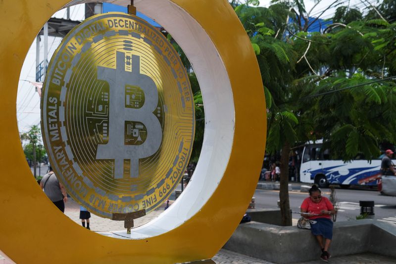 &copy; Reuters. FILE PHOTO: A woman sits by a Bitcoin sign at the Bitcoin Plaza, in Ilopango, El Salvador, May 21, 2024. REUTERS/Jose Cabezas/File Photo