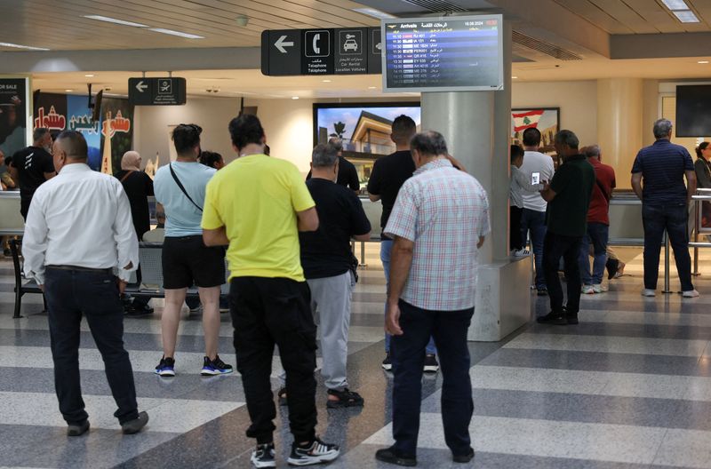 © Reuters. People stand at Beirut-Rafic Hariri International Airport, a day after hand-held radios used by armed group Hezbollah detonated across Lebanon's south, in Beirut, Lebanon September 19, 2024. REUTERS/Mohamed Azakir