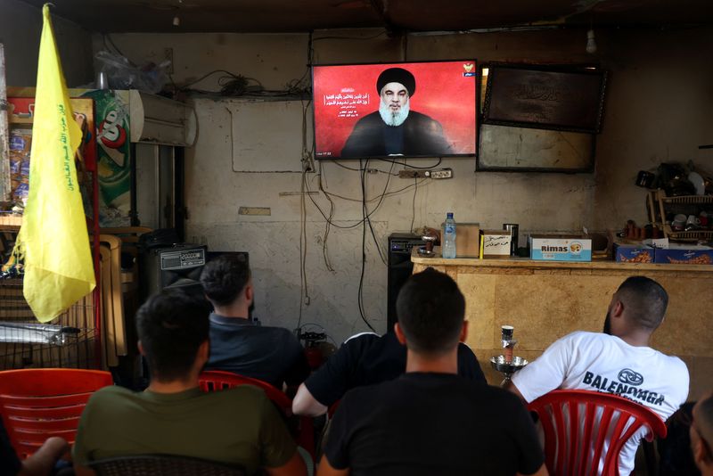 © Reuters. People watch Lebanon's Hezbollah leader Sayyed Hassan Nasrallah delivering a televised address, as they sit at a cafe in Sidon, Lebanon September 19, 2024. REUTERS/Aziz Taher