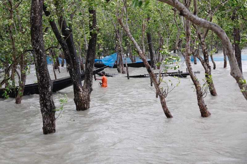 © Reuters. FILE PHOTO: A man moves his boat to tie it to a safer place before the Cyclone Remal hits the country in the Shyamnagar area of Satkhira, Bangladesh, May 26, 2024. REUTERS/Mohammad Ponir Hossain/File Photo