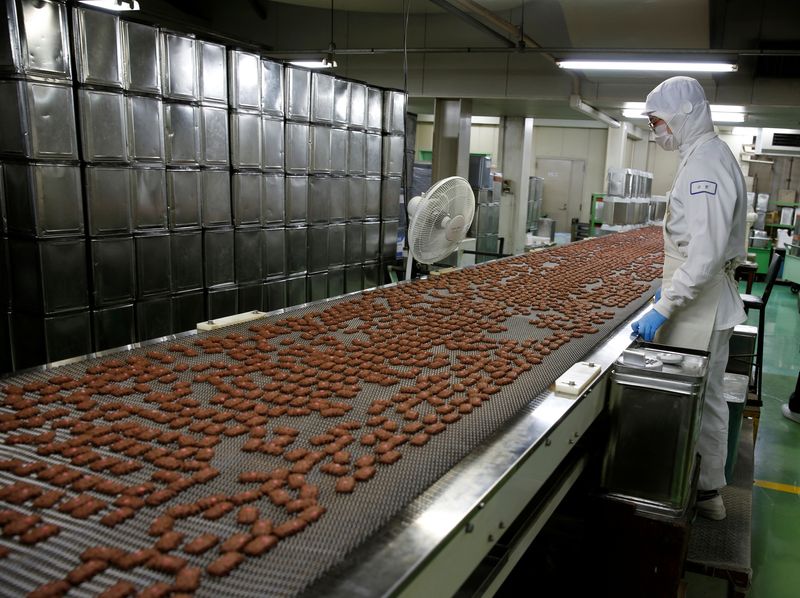 © Reuters. A worker inspects rows of freshly baked cookies on a production line at Izumiya Tokyoten's factory in Kawasaki, south of Tokyo, Japan July 9, 2024. REUTERS/David Dolan/File Photo