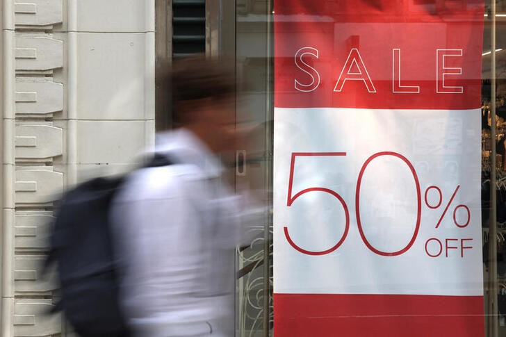 © Reuters. A shopper walks past a ‘Sale 50% off’ sign displayed on the window of a retail store on Oxford Street in London, Britain, August 27, 2024. REUTERS/Hollie Adams/File Photo