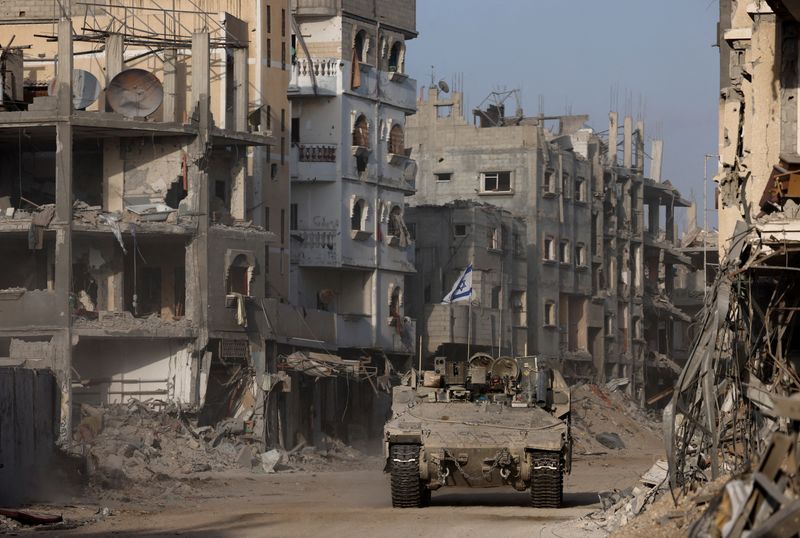 &copy; Reuters. An armoured vehicle drives as damaged buildings are seen in the background, amid the ongoing ground operation of the Israeli army against Palestinian Islamist group Hamas, in the Gaza Strip, September 13, 2024. REUTERS/Amir Cohen/File Photo