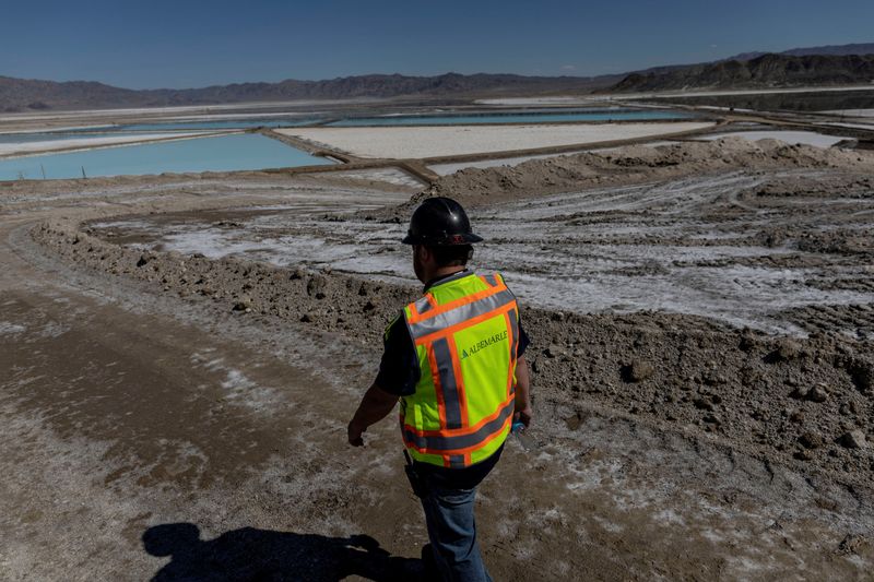 © Reuters. FILE PHOTO: An employee walks near lithium evaporation ponds at Albemarle Lithium production facility in Silver Peak, Nevada, U.S. October 6, 2022. REUTERS/Carlos Barria/File photo