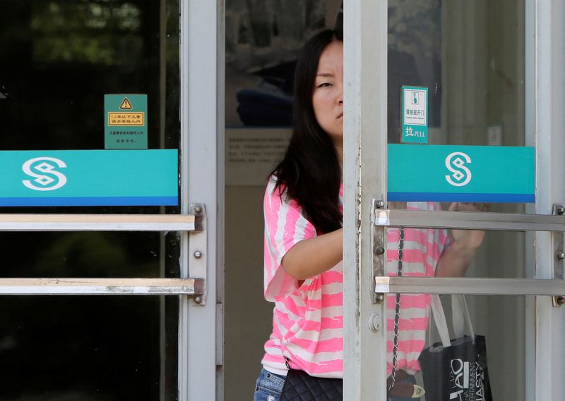 &copy; Reuters. FILE PHOTO: A customer opens the door to a branch of China Minsheng Bank in Beijing, June 27, 2013.  REUTERS/Jason Lee/File Photo