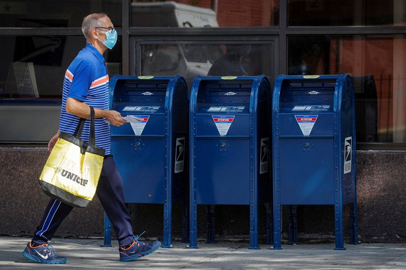 &copy; Reuters. FILE PHOTO: A man carries letters into a United States Postal Service (USPS) post office in the Brooklyn borough of New York City, U.S., August 21, 2020. REUTERS/Brendan McDermid/File Photo