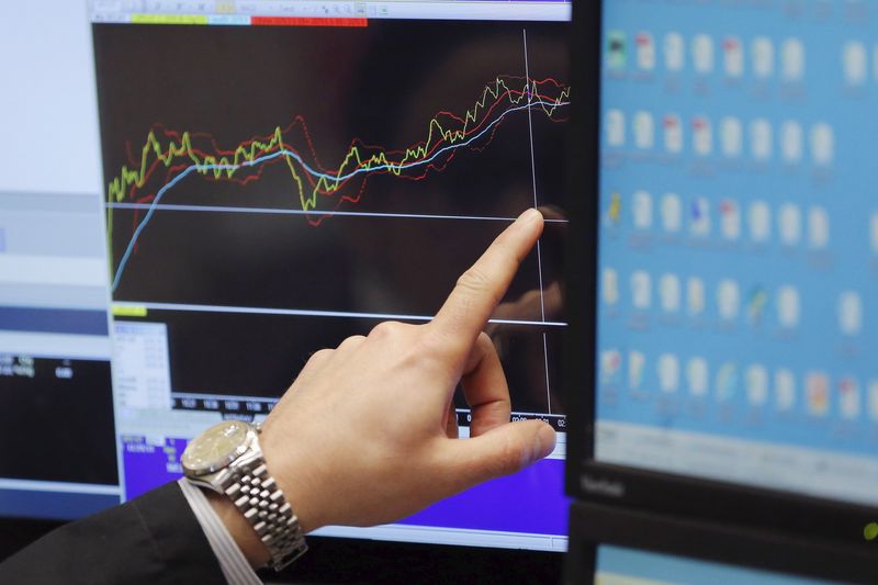 © Reuters. FILE PHOTO: A trader points at a chart on a monitor above the floor of the New York Stock Exchange in New York in this illustration. REUTERS/Lucas Jackson/File Photo