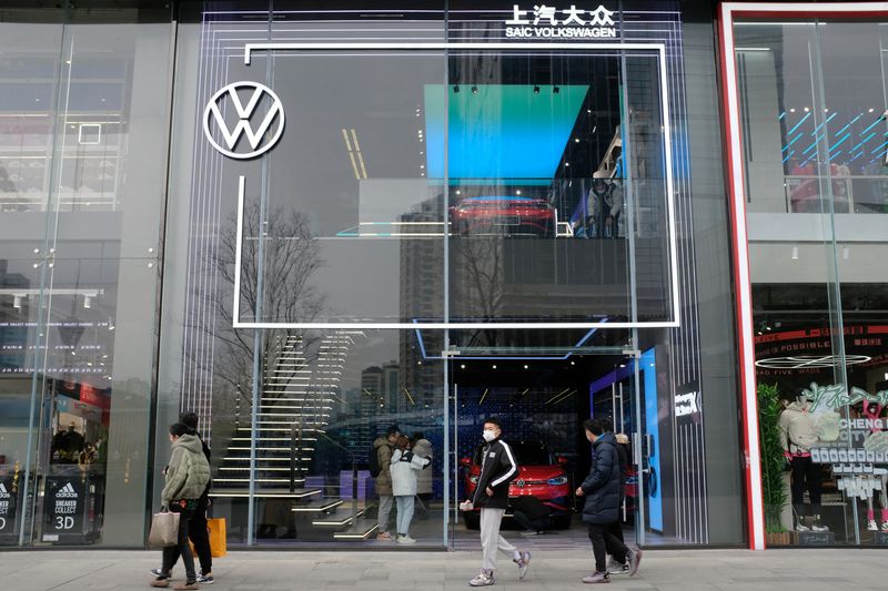 © Reuters. FILE PHOTO: People walk past an ID. Store X showroom of SAIC Volkswagen in Chengdu, Sichuan province, China January 10, 2021. REUTERS/Yilei Sun/File Photo