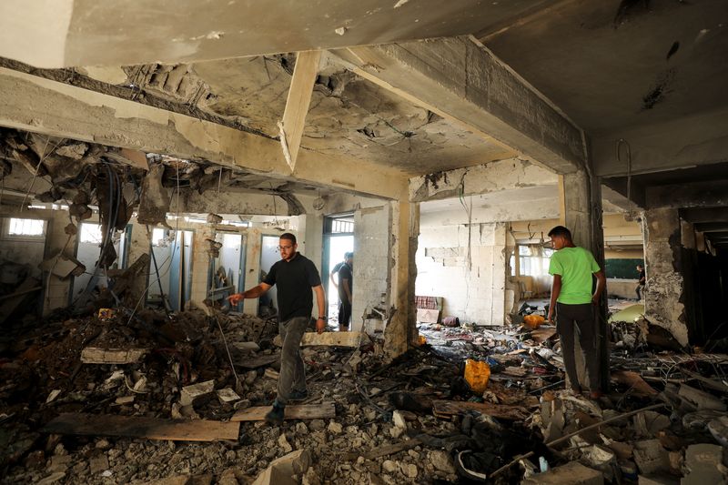 © Reuters. Palestinians inspect a school, which was sheltering displaced people, after it was hit by an Israeli strike, amid the Israel-Hamas conflict, in Gaza City, September 21, 2024. REUTERS/Dawoud Abu Alkas