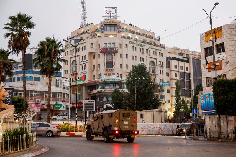 © Reuters. A military vehicle moves in a street outside the building where the Al Jazeera office is located, in Ramallah, in the Israeli-occupied West Bank, September 22, 2024. REUTERS/Mohammed Torokman