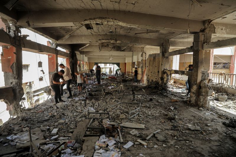 © Reuters. Palestinians inspect the damage to a school sheltering displaced people after it was hit by an Israeli strike, amid the Israel-Hamas conflict, at Beach refugee camp in Gaza City, September 22, 2024. REUTERS/Dawoud Abu Alkas