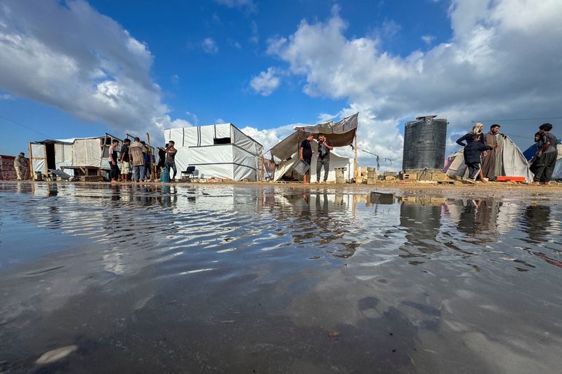 © Reuters. Displaced Palestinians gather as they shelter in a tent camp which was flooded following rainfall, amid the Israel-Hamas conflict, in Khan Younis, in the southern Gaza Strip, September 22, 2024. REUTERS/Mohammed Salem/File Photo