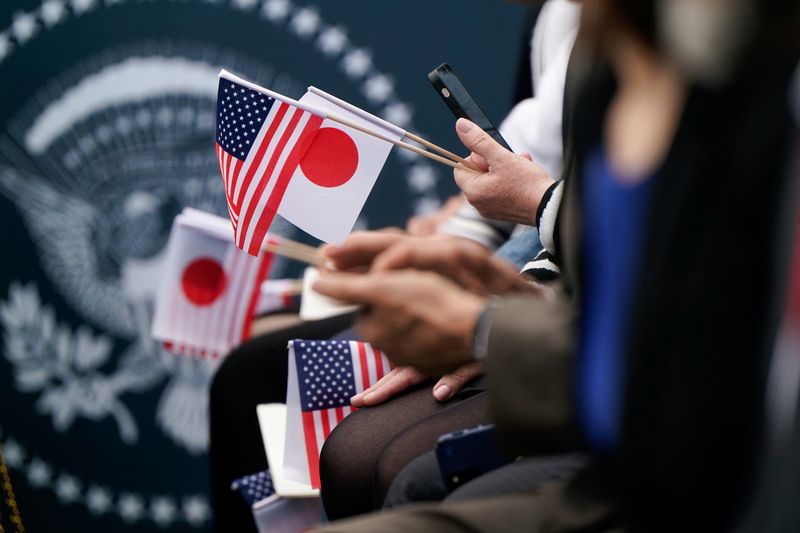 © Reuters. People hold Japan and U.S. flags on the day U.S. President Joe Biden meets Japanese Prime Minister Fumio Kishida and his spouse Yuko Kishida during an official White House State Arrival ceremony on the South Lawn of the White House in Washington, D.C., U.S., April 10, 2024. REUTERS/Elizabeth FrantzFrantz/File Photo