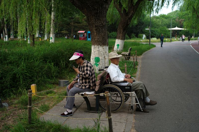 © Reuters. FILE PHOTO: Elderly people rest at a park on a summer day in Beijing, China May 22, 2024. REUTERS/Tingshu Wang/File Photo