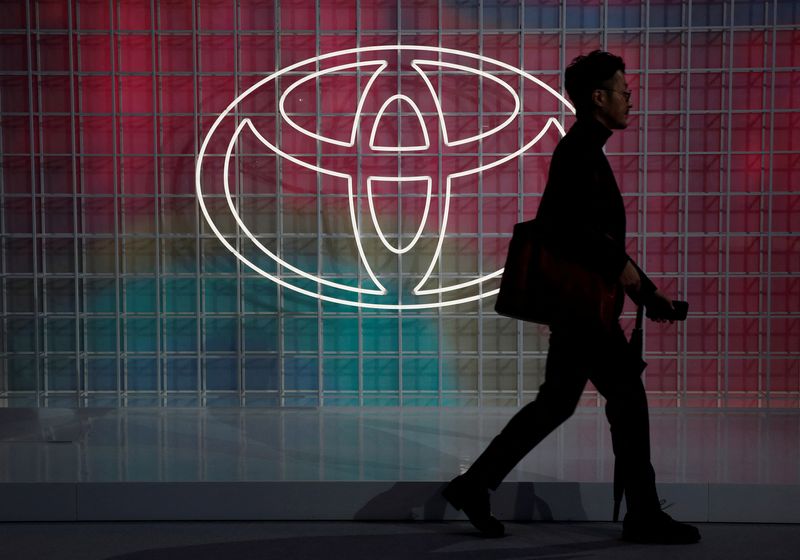 © Reuters. FILE PHOTO: A man walks past a Toyota logo at the Tokyo Motor Show in Tokyo, Japan October 24, 2019. REUTERS/Edgar Su/File Photo