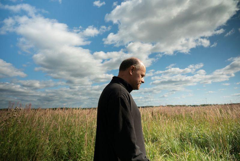 © Reuters. Russian Orthodox priest Ioann Burdin, who was banned from conducting services for denouncing the Russia-Ukraine conflict, which he called 'fratricidal' in a sermon to his parishioners and in comments on social media, walks in a field in Kostroma Region, Russia August 16, 2024. REUTERS/Stringer