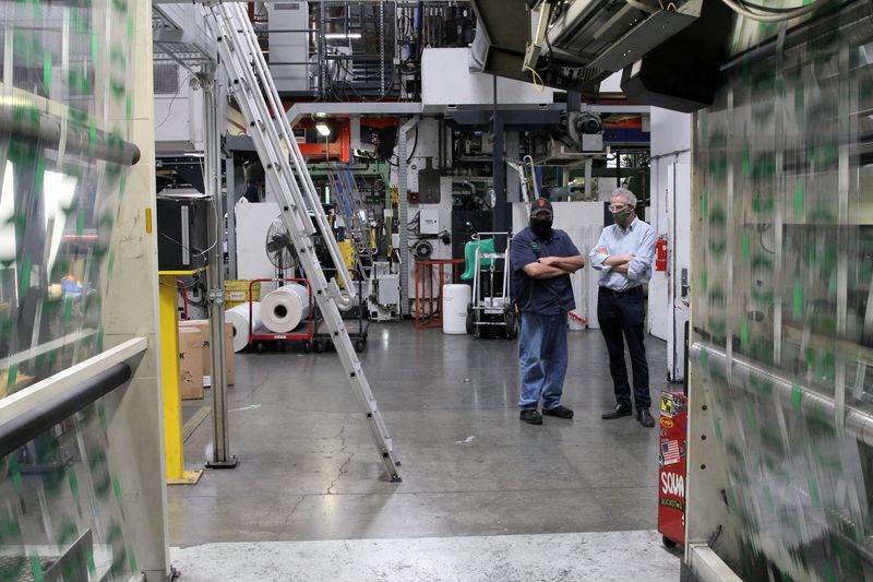 &copy; Reuters. FILE PHOTO: Kevin Kelly, CEO of Emerald Packaging, which makes plastic bags for produce companies, talks with an employee on a production floor of the company during the coronavirus disease (COVID-19) outbreak, in Union City, California, U.S. on May 7, 20