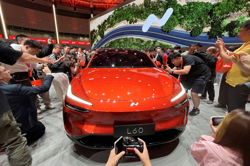 © Reuters. FILE PHOTO: People look at the newly unveiled Onvo L60 SUV, the first vehicle of Chinese electric vehicle (EV) maker Nio's new lower-priced brand, in Shanghai, China May 15, 2024. REUTERS/Zoey Zhang/File Photo