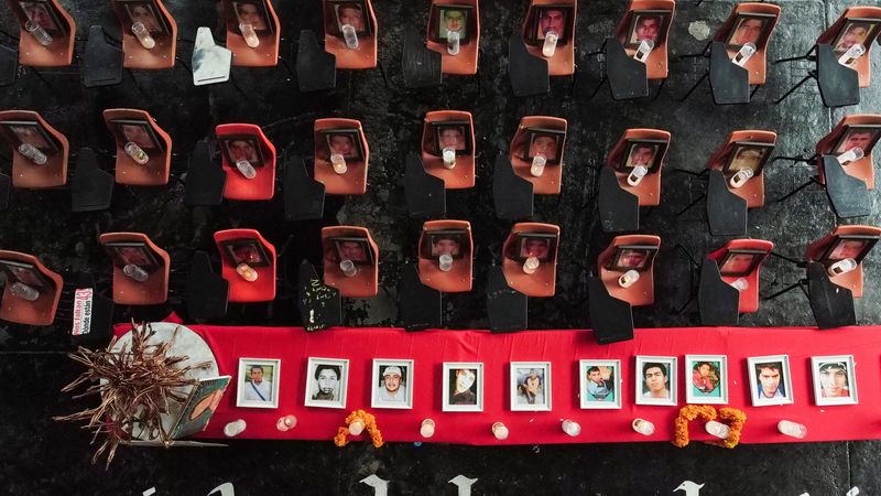 © Reuters. Desks are adorned with votive candles and photos of the murdered students and the 43 missing students of the Ayotzinapa rural teacher-training school, ahead of the 10th anniversary of their disappearance, in Tixtla, Mexico, September 22, 2024. REUTERS/ Quetzalli Nicte-Ha