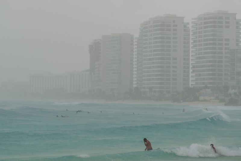 © Reuters. Tourists bathe at a beach as Tropical Storm Helene approaches the Yucatan Peninsula, in Cancun, Mexico September 24, 2024. REUTERS/Paola Chiomante