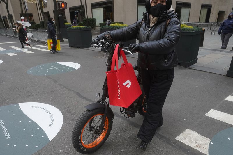 © Reuters. A DoorDash delivery person is pictured on the day they hold their IPO in the Manhattan borough of New York City, New York, U.S., December 9, 2020. REUTERS/Carlo Allegri/File Photo