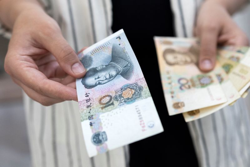 © Reuters. FILE PHOTO: Woman holds Chinese Yuan banknotes in this illustration taken May 30, 2022. REUTERS/Dado Ruvic/Illustration/File photo