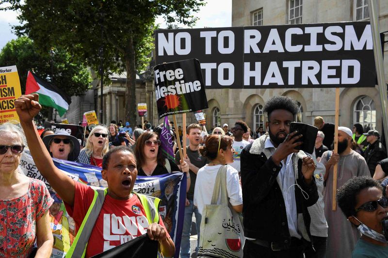 © Reuters. FILE PHOTO: Counter-protesters take part in a protest against Tommy Robinson, during a march organised by Stand Up To Racism and other groups, in London, Britain, July 27, 2024. REUTERS/Chris J Ratcliffe/File Photo