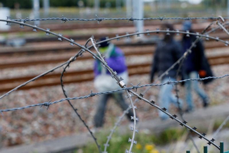 &copy; Reuters. FILE PHOTO: Razor-wire frames migrants who walk near train tracks which lead to the Channel Tunnel in Frethun, near Calais, France, July 29, 2015. .   REUTERS/Pascal Rossignol/File Photo