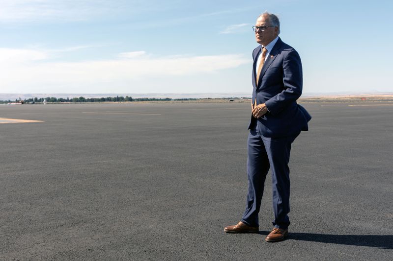 © Reuters. Washington Governor Jay Inslee stands on the tarmac while traveling to an event in Walla Walla, Washington, U.S., September 18, 2024. REUTERS/Matt Mills McKnight