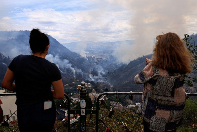 © Reuters. People watch as smoke rises from wildfires, in Quito, Ecuador, September 25, 2024. REUTERS/Karen Toro