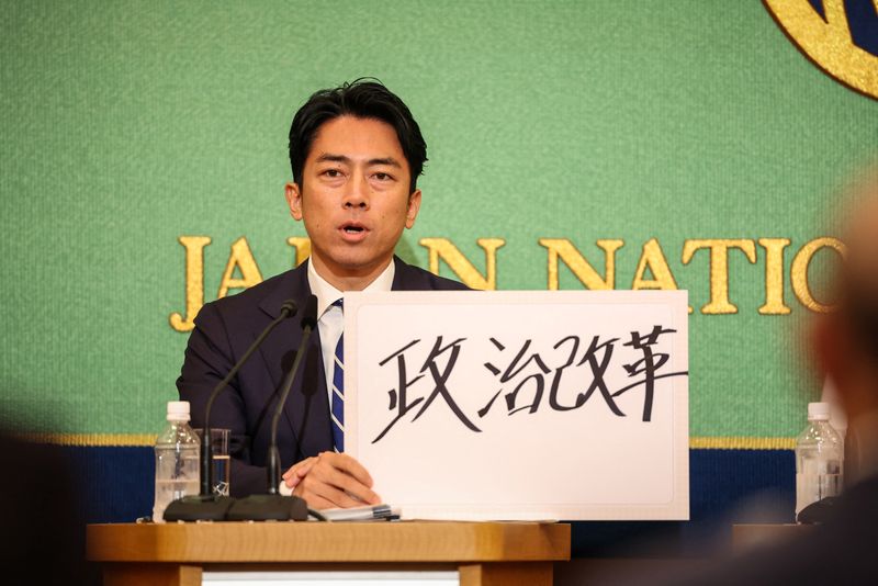 © Reuters. FILE PHOTO: TOKYO, JAPAN - SEPTEMBER 14: Former environment minister Shinjiro Koizumi, a candidate for Japan’s ruling Liberal Democratic Party’s (LDP) presidential election, holds up a sign during a debate at the Nixon Kisha Club in Tokyo, Japan. Japan's Liberal Democratic Party (LDP) is currently in the midst of a leadership election, with the official campaign period commencing on September 12, 2024. Takashi Aoyama/Pool via REUTERS/File Photo