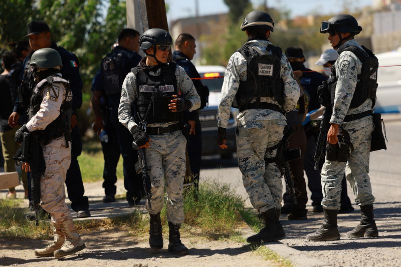 © Reuters. Members of the Mexican National Guard stand guard at a crime scene, as Mexico's Senate approved a constitutional reform that transfers operational command of the National Guard to the Secretariat of National Defense (SEDENA), In Ciudad Juarez, Mexico, September 25, 2024. REUTERS/Jose Luis Gonzalez