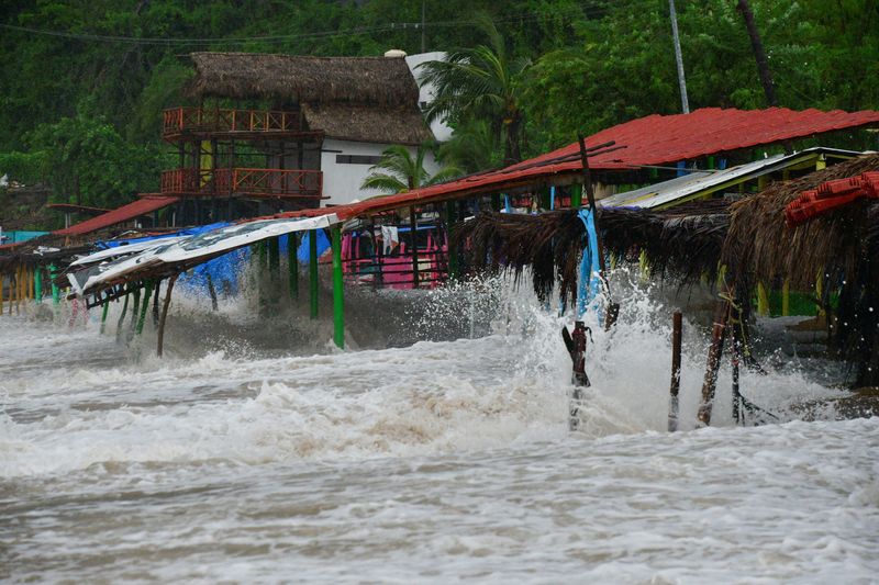 © Reuters. Waves break into restaurants on the beach as Tropical Storm John is on track to become a hurricane again, hurtling back towards communities across the Pacific coast, in Acapulco, Mexico September 25, 2024. REUTERS/Javier Verdin