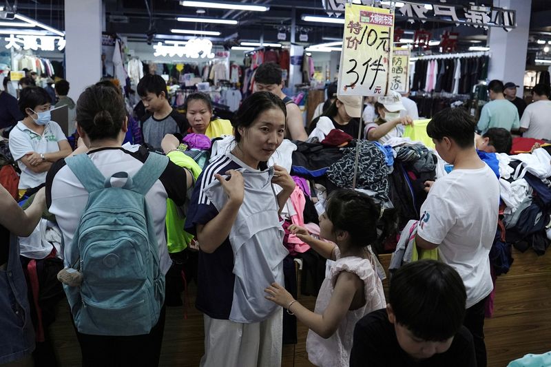 © Reuters. Customers shop at a discount clothing store in Beijing, China, July 14, 2024. REUTERS/Tingshu Wang/ File photo