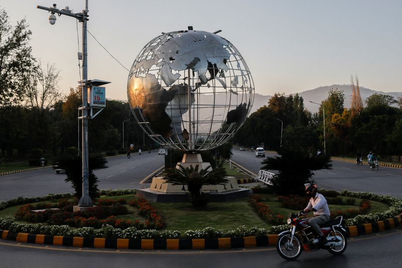 &copy; Reuters. FILE PHOTO: A man on a motorbike rides past the Globe roundabout at Constitution Avenue during sunset hours in Islamabad, Pakistan October 3, 2023. REUTERS/Akhtar Soomro/File photo