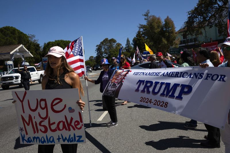 &copy; Reuters. FILE PHOTO: A supporter of Democratic presidential nominee and U.S. Vice President Kamala Harris and vice presidential nominee Minnesota Governor Tim Walz crashes a rally for Republican presidential nominee and former U.S. President Donald Trump next to a