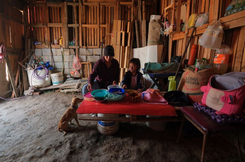 © Reuters. Lourdes Milagro Gonza, 23, sits at the table to share lunch with her daughter, Ashley, with rations of stew that her family prepared and handed to help her with the costs of living, at her home in a settlement in Salta, Argentina September 12, 2024. REUTERS/Javier Corbalan