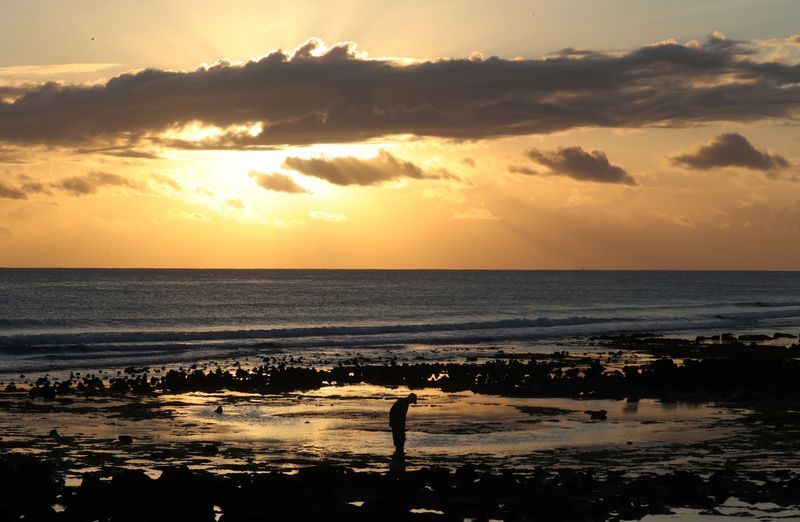 © Reuters. FILE PHOTO: The sun rises as fishermen gather clams and bait in Pemba, Mozambique, July 12, 2018. Picture taken July 12, 2018. REUTERS/Mike Hutchings/File Photo