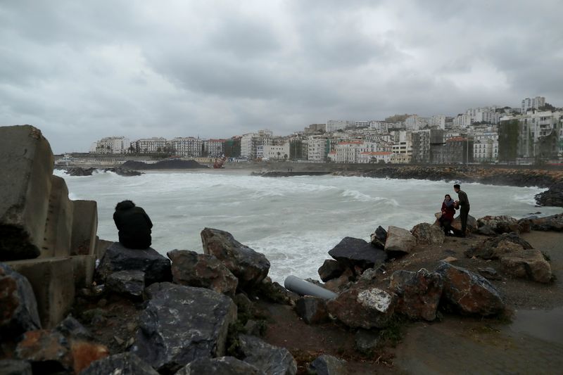 &copy; Reuters. People are pictured in the rainy day on the edge of the Ketani beach at Bab El Oued in Algiers, Algeria March 21, 2019.REUTERS/ Zohra Bensemra/File Photo