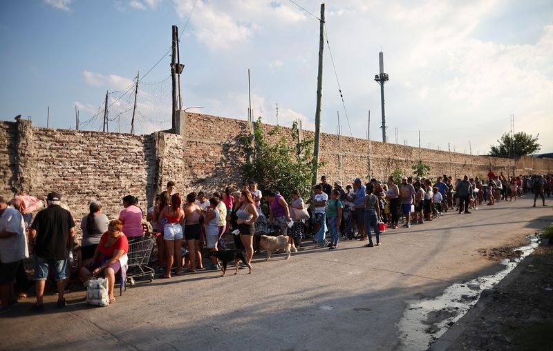 © Reuters. FILE PHOTO: People wait in line to receive a charity food bag, outside the NGO Sal de la tierra, in Villa Fiorito, a working-class neighborhood on the outskirts of Buenos Aires, Argentina February 27, 2024. REUTERS/Agustin Marcarian/File Photo