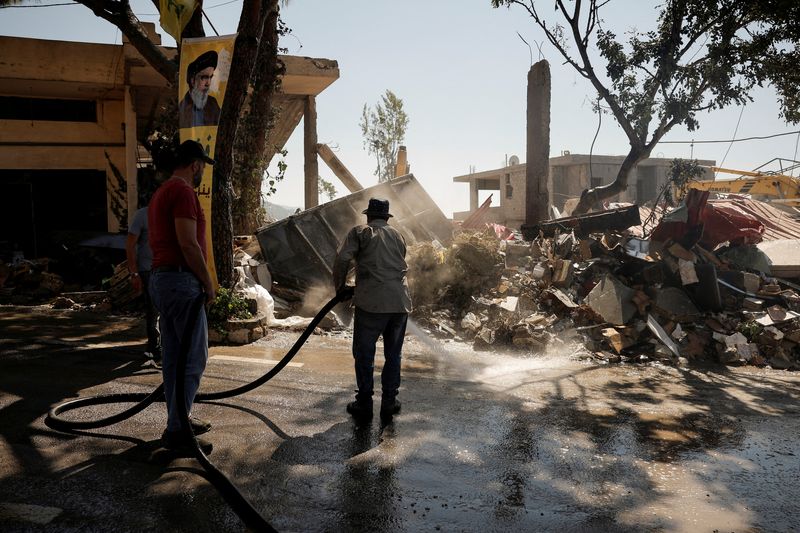 © Reuters. People clean the streets a day after an Israeli strike on residential buildings in the village of Maaysrah, north of Beirut, Lebanon, September 26, 2024. REUTERS/Louisa Gouliamaki.   