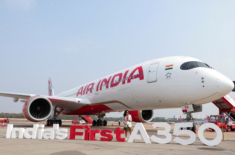 © Reuters. FILE PHOTO: A woman stands next to the Air India Airbus A350 jet on display at the Wings India 2024 aviation event at Begumpet Airport, Hyderabad, India January 18, 2024. REUTERS/Almaas Masood/File Photo