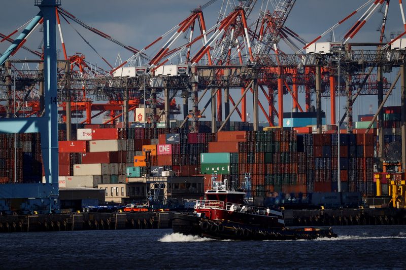 &copy; Reuters. FILE PHOTO: A tugboat passes shipping containers being unloaded and stacked on a pier at Port Newark, New Jersey, U.S., November 19, 2021. REUTERS/Mike Segar/File Photo