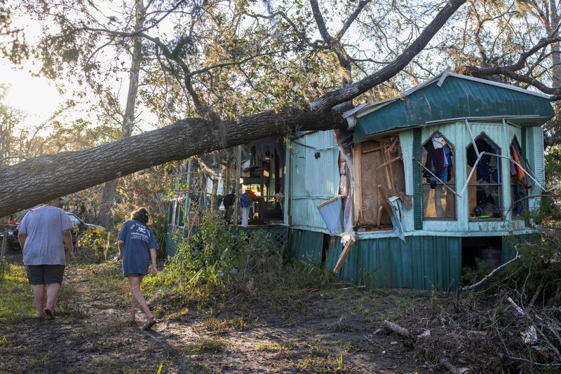 &copy; Reuters. Nash Harris and his mother Alicia walk towards the home where they had been living to try and find some salvageable clothing after Hurricane Helene made landfall in Steinhatchee, Florida, U.S., September 27, 2024. REUTERS/Kathleen Flynn