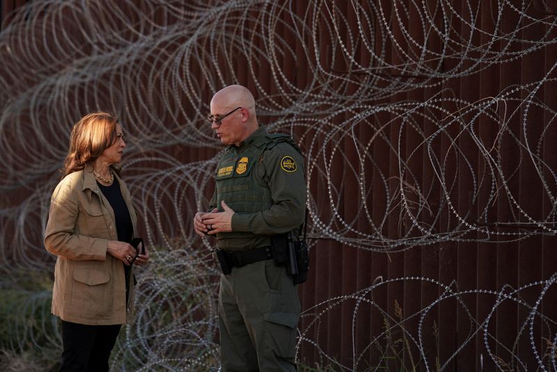 &copy; Reuters. A candidata democrata à presidência e vice-presidente dos EUA, Kamala Harris, visita o muro da fronteira com um agente da Patrulha da Fronteira, perto de Tucson, Arizona, EUAn27/09/2024nREUTERS/Kevin Lamarque