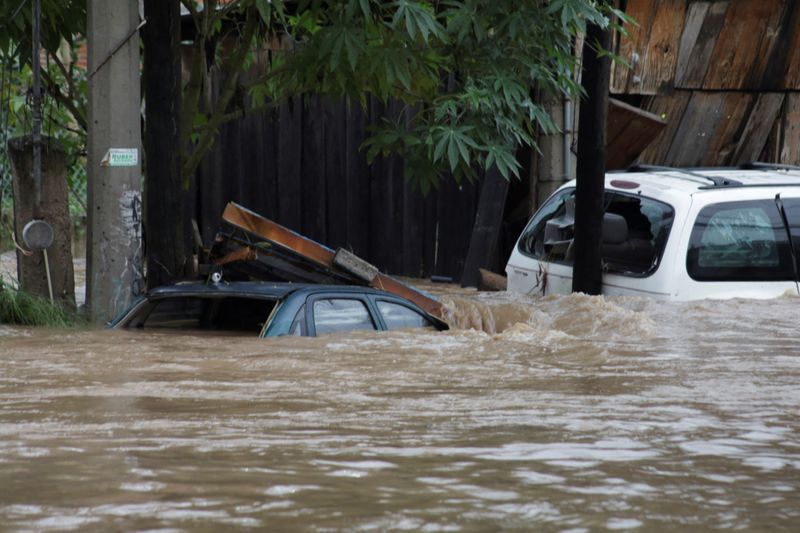 © Reuters. Cars partially submerged are seen damaged by a river which overflowed its banks after the passing of Tropical Storm John, in Chilpancingo, Mexico September 27, 2024. REUTERS/Oscar Guerrero