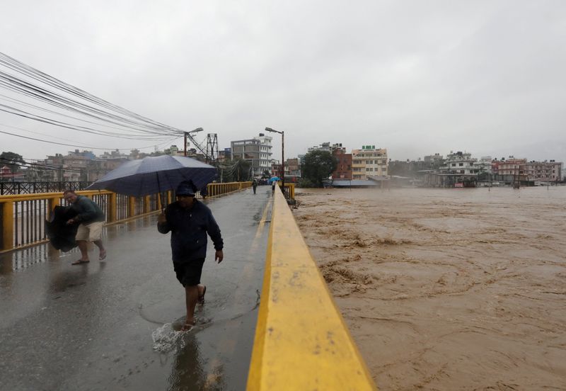 &copy; Reuters. FILE PHOTO: People cross the bridge amid the overflowing Bagmati River following heavy rains, in Kathmandu, Nepal September 28, 2024. REUTERS/Navesh Chitrakar/File Photo